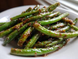 Close-up of vibrant, glossy green beans coated in a sticky honey garlic sauce, ready to serve.