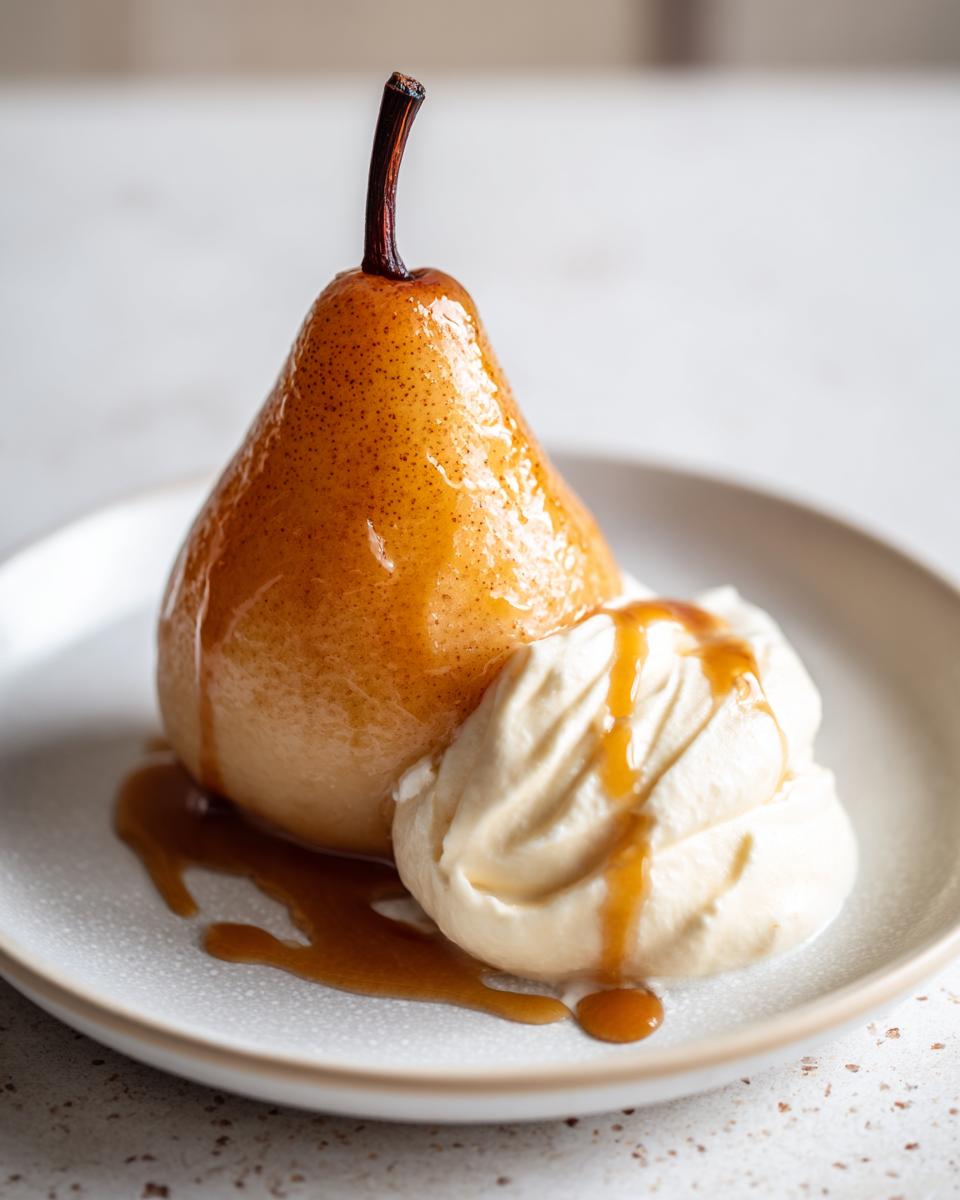 A beautifully glazed poached pear served with a dollop of whipped cream and caramel sauce.