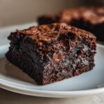 Close-up of a fudgy square of sweet potato brownies showing melted chocolate chips embedded in the rich, dark interior.