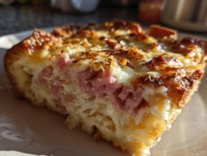 Close-up of a golden-brown slice of homemade Reuben bake showing layers of ham, sauerkraut, and melted cheese.