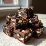 A tempting stack of rich, dark Oreo fudge squares studded with white chocolate chunks and cookie pieces.