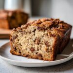Close-up of a moist slice of sweet alabama pecan bread showing the crumb texture and pecans.