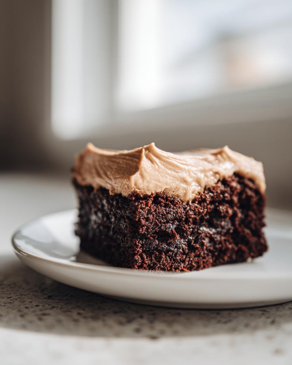 A close-up of a rich, dark chocolate banana bread brownies square topped with swirled peanut butter frosting.